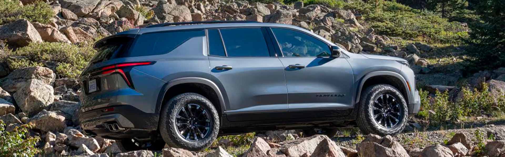 2025 Chevrolet Traverse off-road SUV in rugged terrain with rocky landscape, perfect for adventurous trips and outdoor exploration.