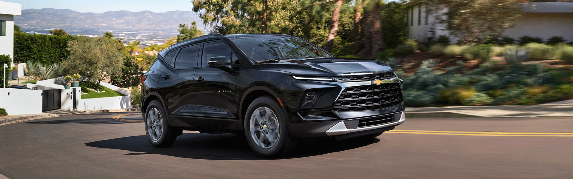 Black 2026 Chevy Blazer in motion on a city road highlighting its sporty design